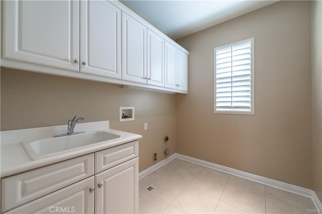 washroom with hookup for a gas dryer, washer hookup, a sink, baseboards, and cabinet space