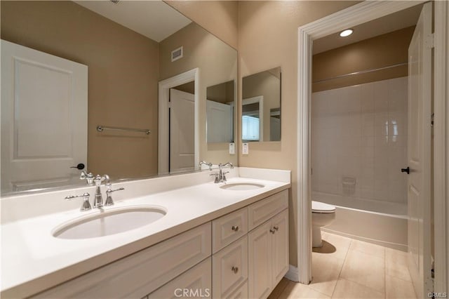 bathroom featuring toilet, tile patterned flooring, double vanity, and a sink