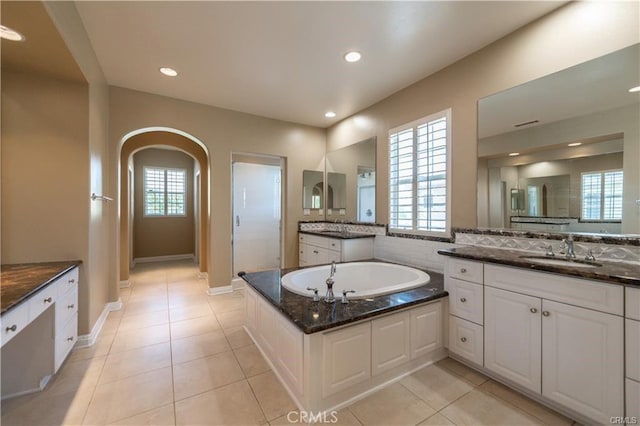 bathroom with recessed lighting, plenty of natural light, a sink, and tile patterned floors