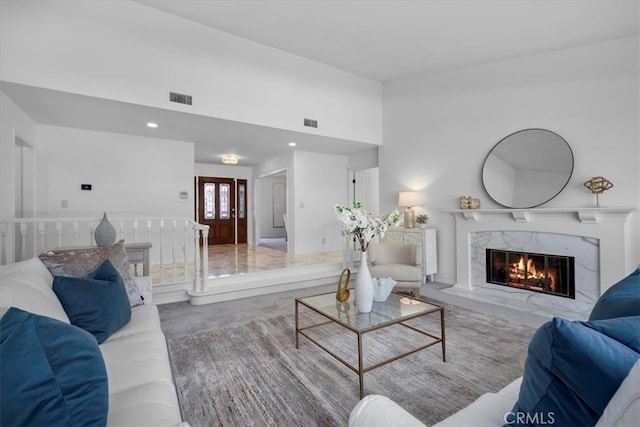living room featuring visible vents, recessed lighting, a premium fireplace, and carpet floors