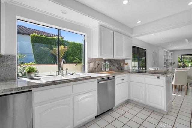kitchen featuring light tile patterned floors, decorative backsplash, stainless steel dishwasher, a sink, and black electric cooktop