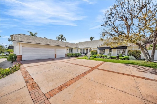 ranch-style house featuring concrete driveway, an attached garage, and stucco siding