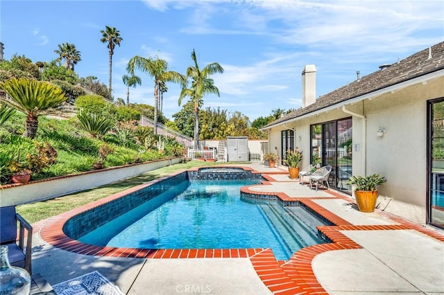 pool with an in ground hot tub, a fenced backyard, and a patio area