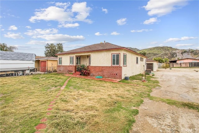 rear view of house featuring fence, a yard, cooling unit, crawl space, and brick siding