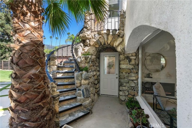 doorway to property with stone siding and stucco siding