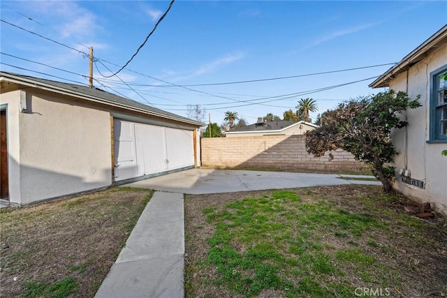 view of yard with a patio area, fence, and an outdoor structure