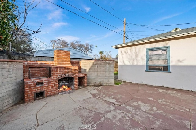 view of patio / terrace featuring an outdoor brick fireplace