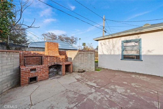 view of patio / terrace featuring an outdoor brick fireplace