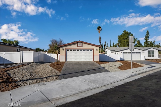 view of front of home featuring concrete driveway, an attached garage, a gate, fence, and stucco siding