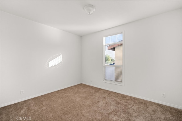 carpeted spare room with baseboards