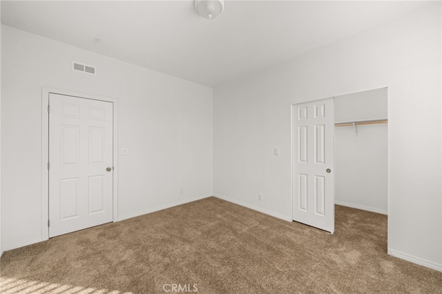 unfurnished bedroom featuring a closet, carpet, and visible vents