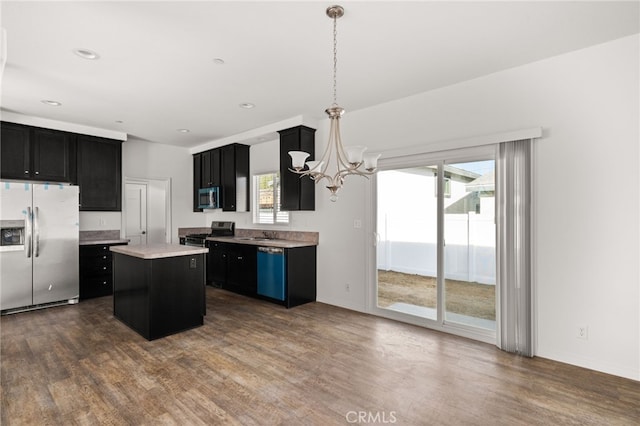 kitchen with appliances with stainless steel finishes, a healthy amount of sunlight, dark wood finished floors, and dark cabinets