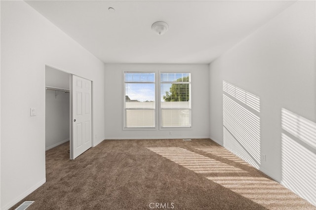 unfurnished bedroom with baseboards, a closet, visible vents, and carpet flooring