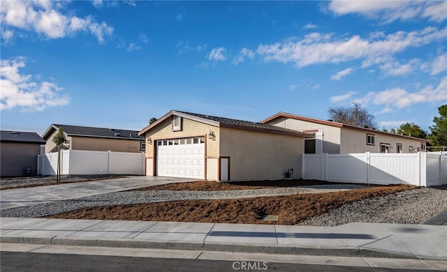 view of front of house featuring driveway, a garage, fence, and stucco siding