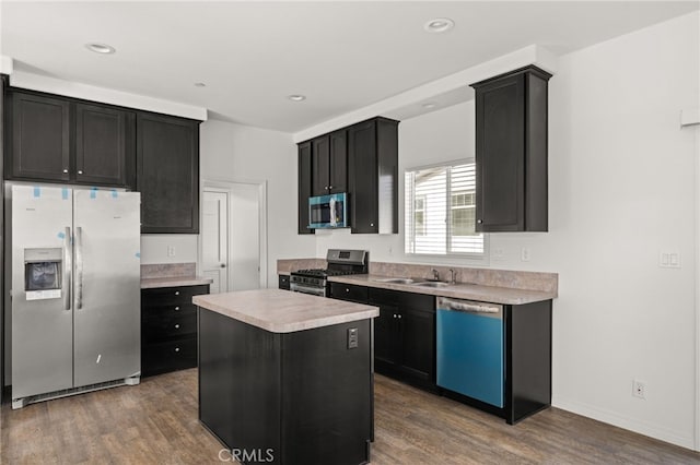 kitchen with stainless steel appliances, light countertops, dark wood finished floors, and dark cabinets