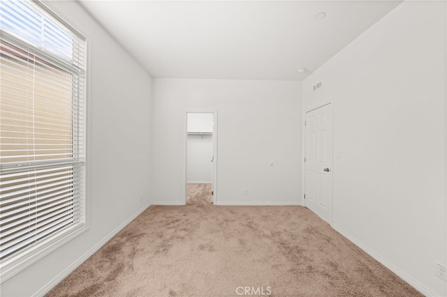 unfurnished room featuring carpet and baseboards