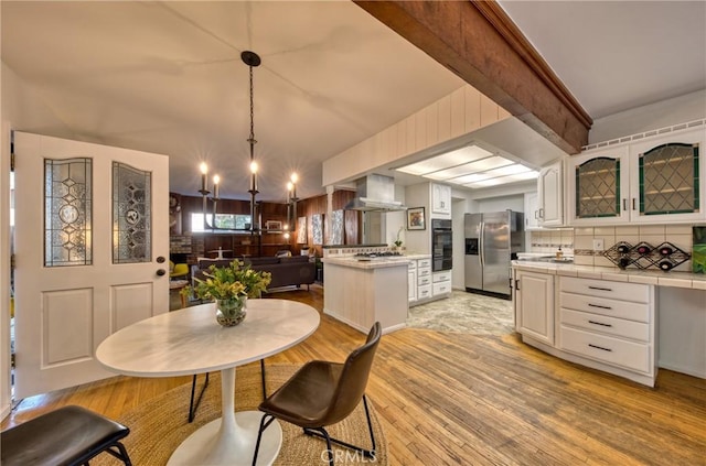 dining room with light wood-style flooring and beamed ceiling