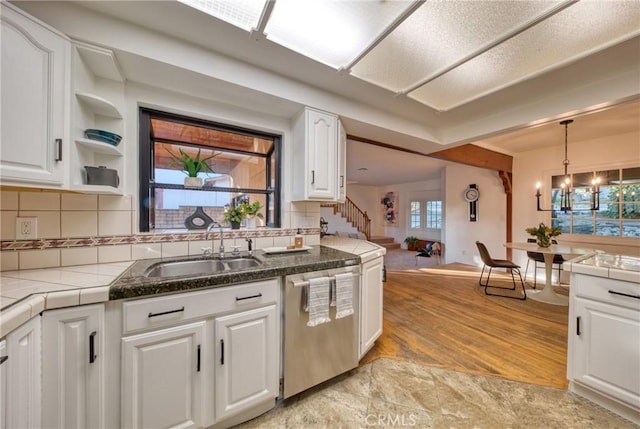 kitchen with white cabinets, a sink, and stainless steel dishwasher