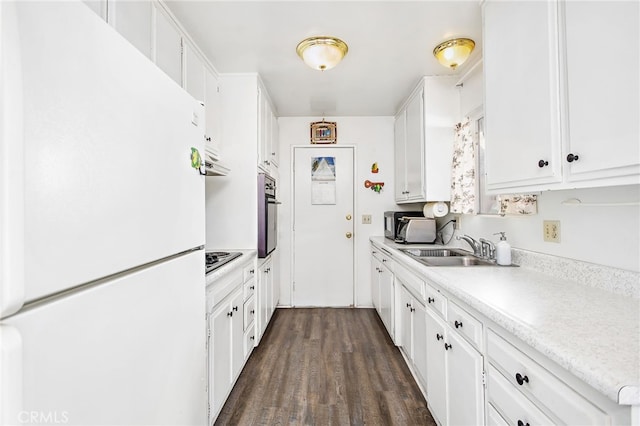 kitchen with dark wood-style floors, freestanding refrigerator, white cabinets, and light countertops