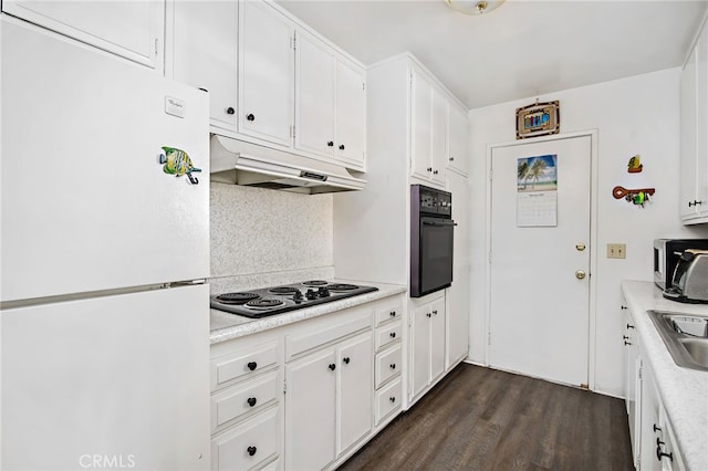 kitchen with under cabinet range hood, dark wood-type flooring, a sink, white cabinets, and black appliances