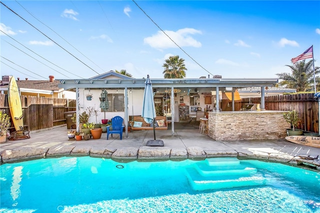 back of house with outdoor dry bar, a patio area, fence, and a fenced in pool