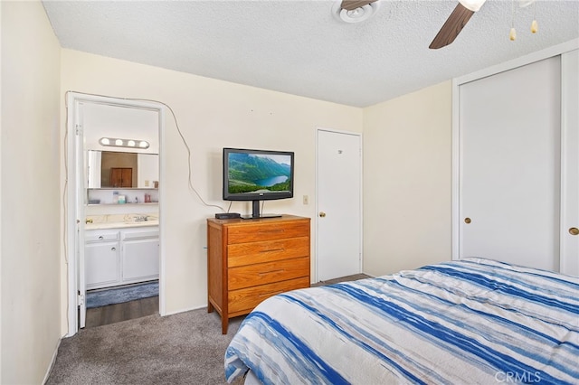 carpeted bedroom with a closet, connected bathroom, a ceiling fan, and a textured ceiling