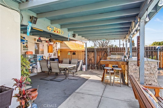 view of patio with outdoor dining area, fence, and a grill