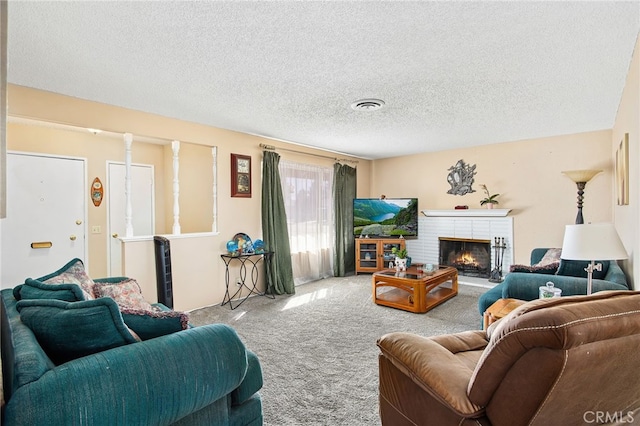 living room with a textured ceiling, carpet floors, a fireplace, and visible vents