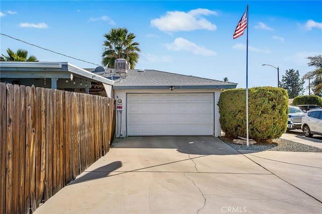 garage with fence and central air condition unit