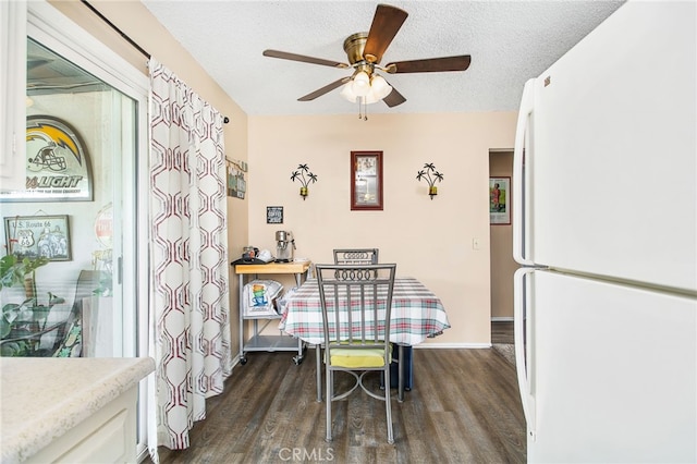 dining space with baseboards, a ceiling fan, dark wood-style flooring, and a textured ceiling