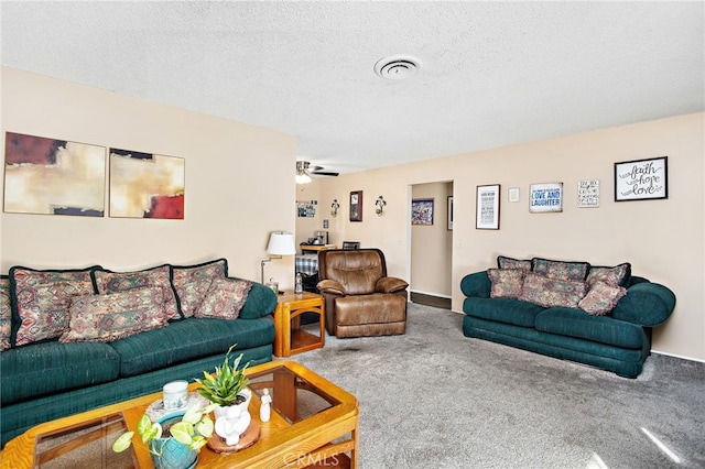 carpeted living room with a textured ceiling, visible vents, and a ceiling fan