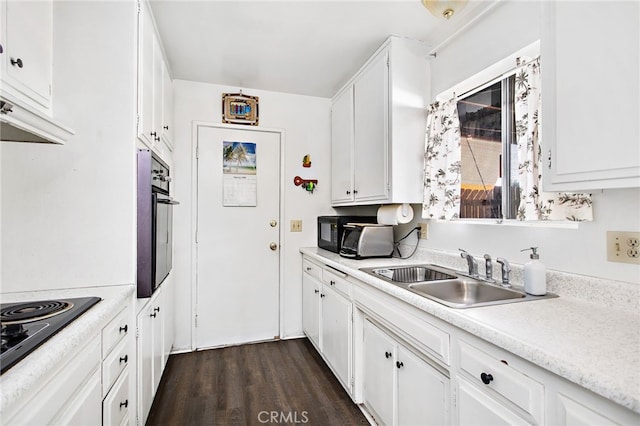 kitchen featuring a sink, white cabinetry, light countertops, black appliances, and dark wood finished floors