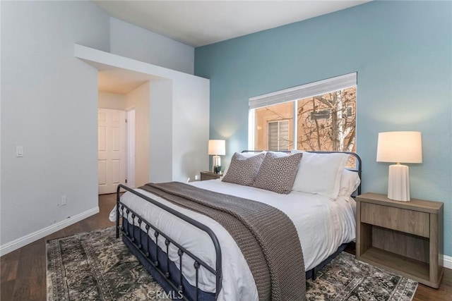 bedroom with baseboards and wood finished floors