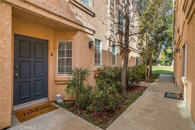 property entrance with stucco siding