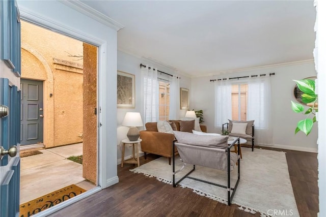 sitting room featuring crown molding, baseboards, and wood finished floors