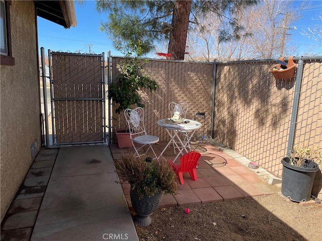 view of patio featuring a gate and fence