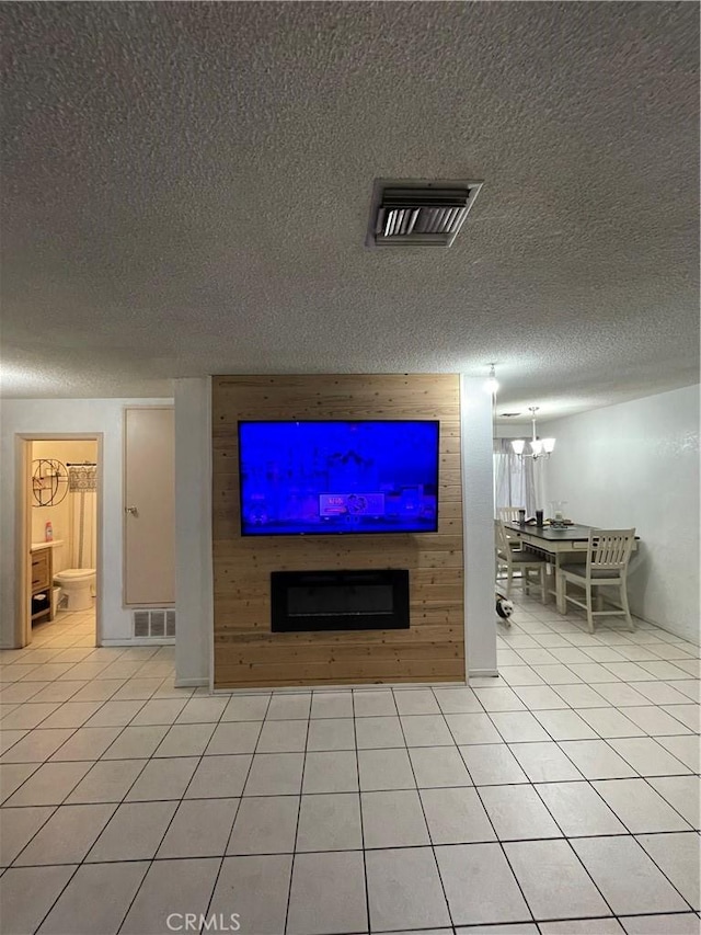 unfurnished living room featuring light tile patterned floors, visible vents, and a notable chandelier