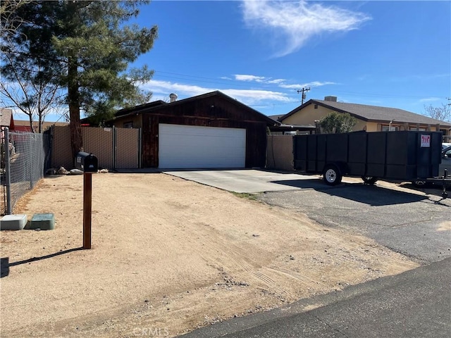 view of front of home featuring driveway, an attached garage, and fence