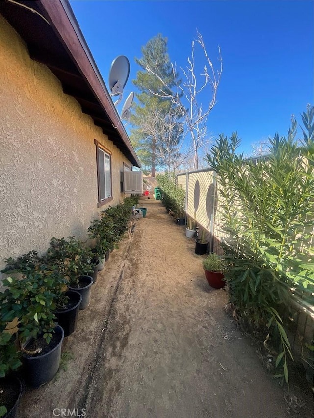 view of property exterior with fence and stucco siding