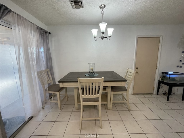 dining space with a chandelier, visible vents, a textured ceiling, and light tile patterned floors