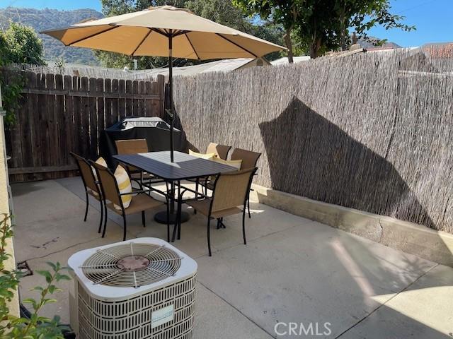 view of patio / terrace featuring a fenced backyard, central AC unit, and outdoor dining area