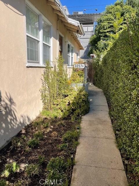 view of home's exterior with fence and stucco siding