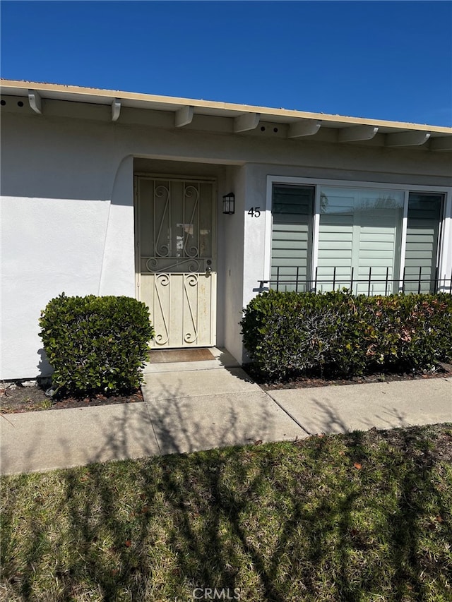 property entrance with stucco siding