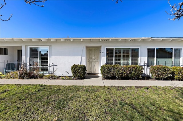 3902 Vista Campana N Unit 45, Oceanside, CA 92057 - view of front of home with fence, stucco siding, and a front lawn