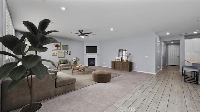 living area with a fireplace, baseboards, and recessed lighting