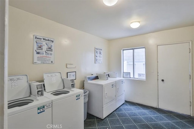 common laundry area with independent washer and dryer and dark tile patterned floors