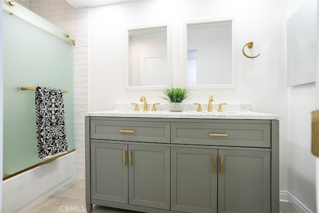 full bathroom featuring double vanity, bathtub / shower combination, and a sink