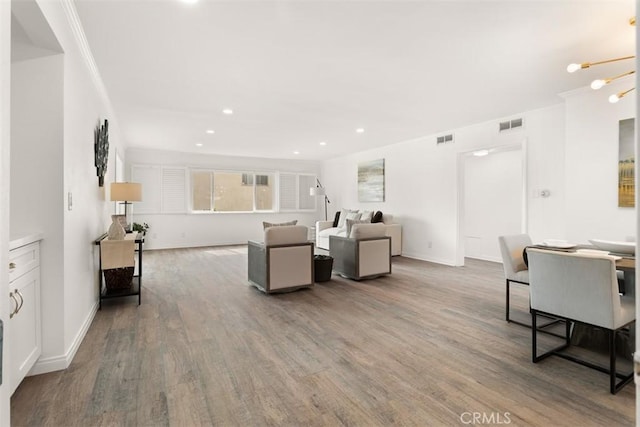 living area featuring recessed lighting, visible vents, and wood finished floors