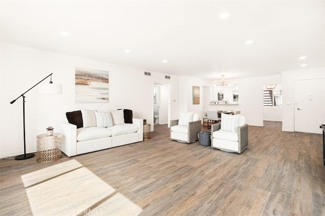 living room with light wood finished floors, visible vents, and recessed lighting