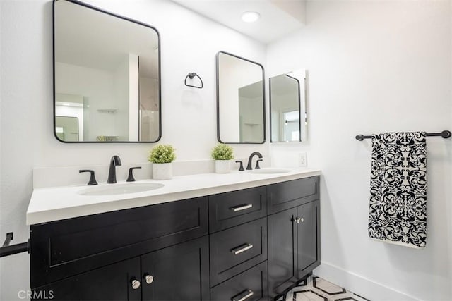 bathroom featuring double vanity, baseboards, and a sink